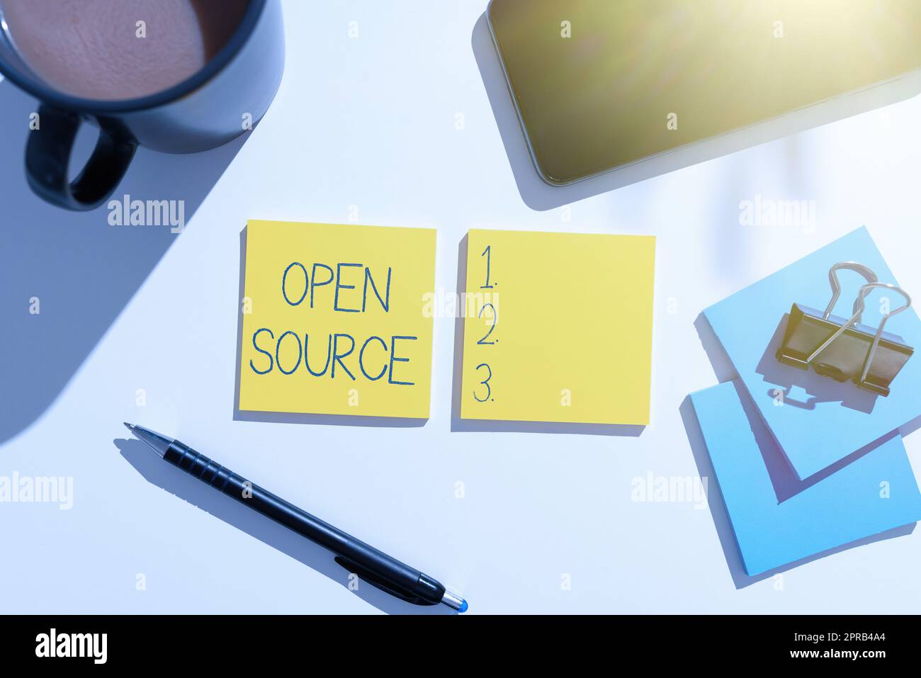 Affichage conceptuel Open Source. Mot écrit sur le logiciel d'identification qui code source original librement disponible idées importantes sur deux Notes sur le bureau avec stylo, téléphone, tasse et trombone. Banque D'Images