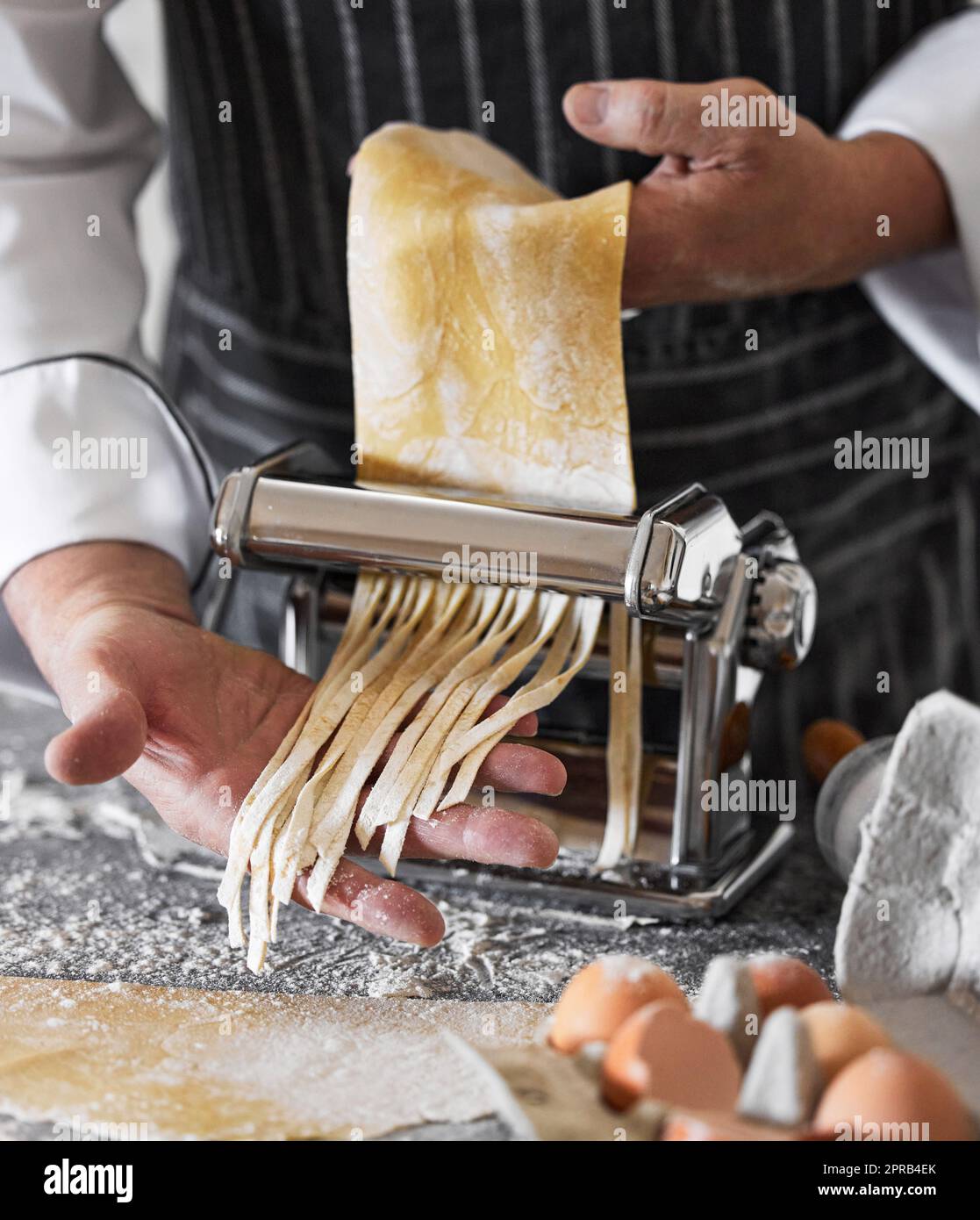 Des pâtes fraîchement préparées pour votre plaisir. Un homme méconnaissable prépare des pâtes fraîchement préparées. Banque D'Images