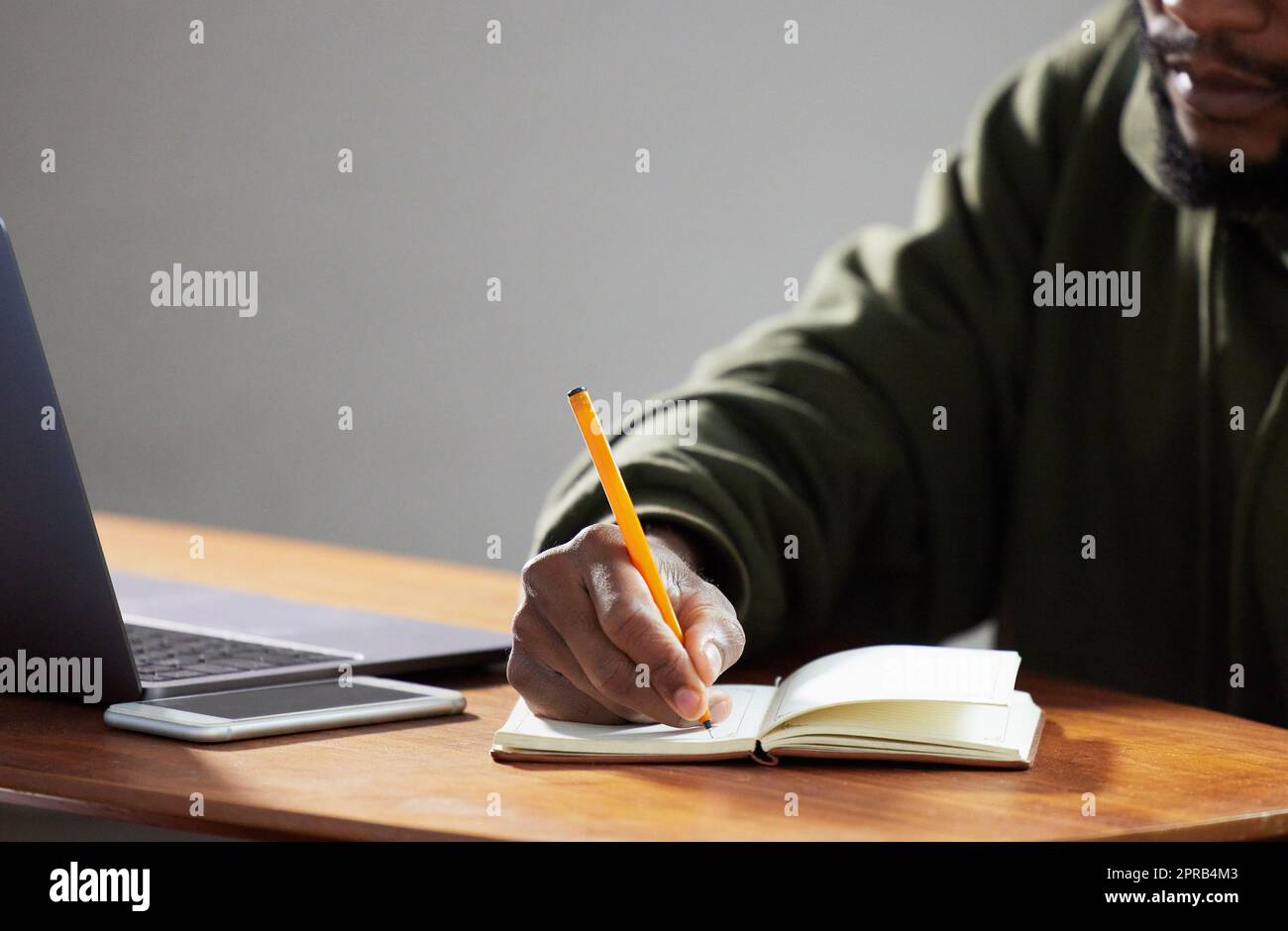 Écrire vos pensées peut être thérapeutique. Un homme méconnaissable écrire dans un carnet dans un bureau. Banque D'Images