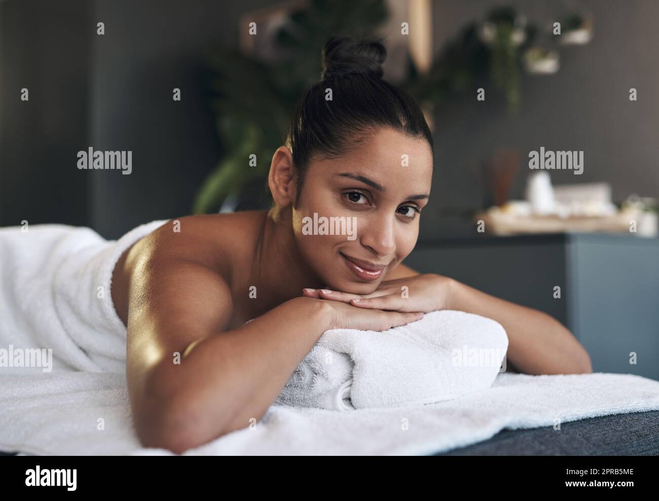 On m'a appelé pour me détendre et j'ai répondu. Portrait d'une jeune femme allongé sur un lit de massage dans un spa. Banque D'Images