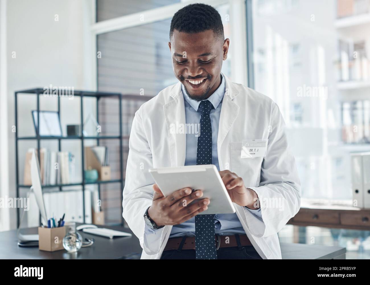 Le domaine médical évolue. Un jeune médecin utilisant une tablette numérique dans un bureau. Banque D'Images