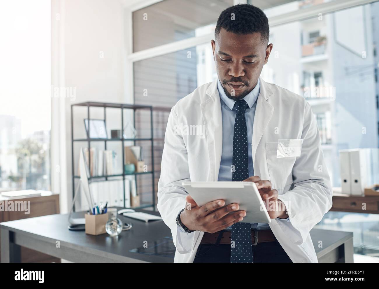 Tout est possible quand vous restez concentré. Un jeune médecin utilisant une tablette numérique dans un bureau. Banque D'Images