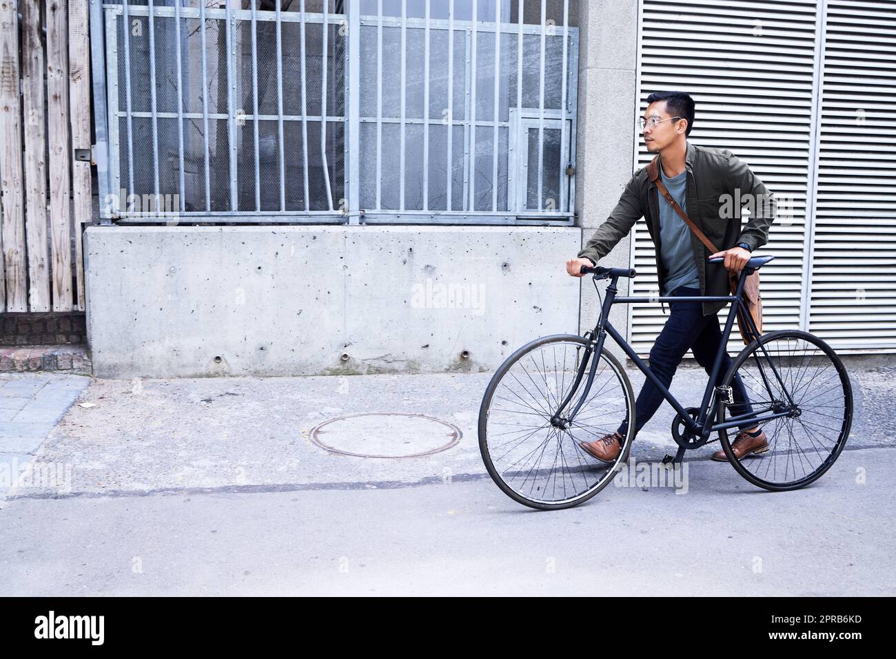 Je garde mes trajets en ville respectueux de l'environnement. Un jeune homme utilisant un vélo dans la ville. Banque D'Images