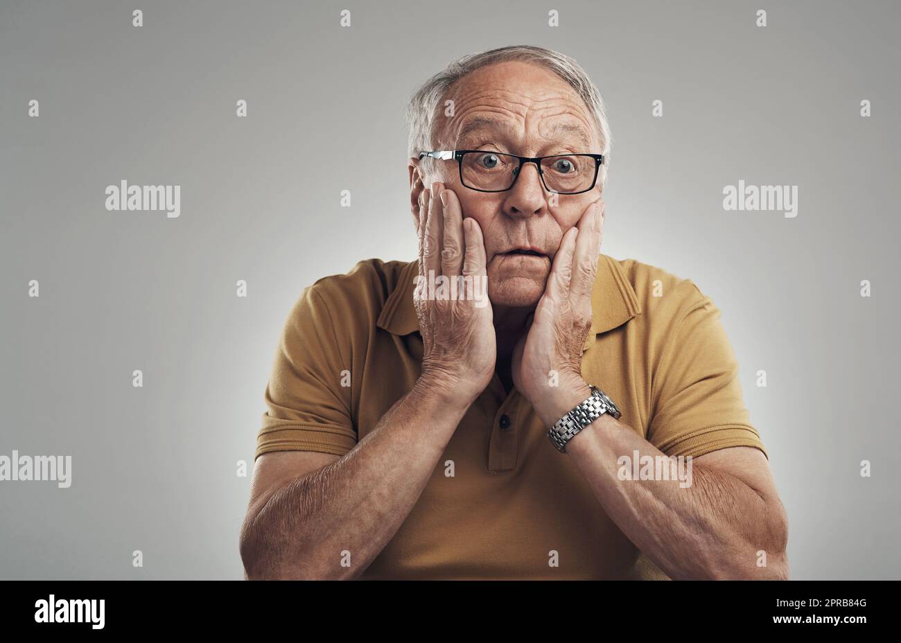 Ce ne peut pas être vrai. Photo studio d'un homme âgé en incrédulité sur fond gris. Banque D'Images