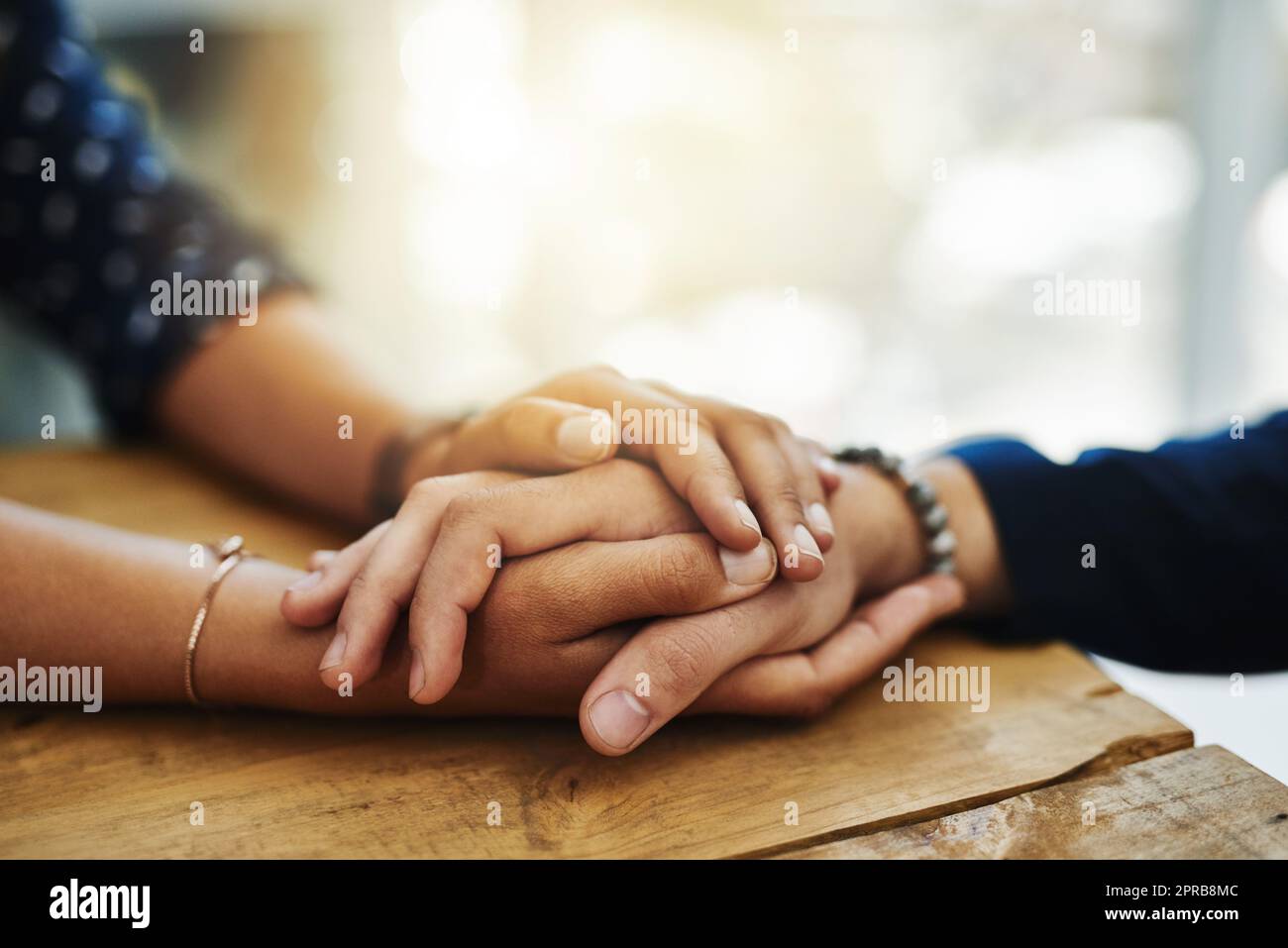 Tenir les mains, le soutien et le confort de deux personnes parlant à travers un problème difficile. Gros plan d'amis montrant le soin et l'amour à travers un temps difficile, se consolant les uns les autres et le collage Banque D'Images