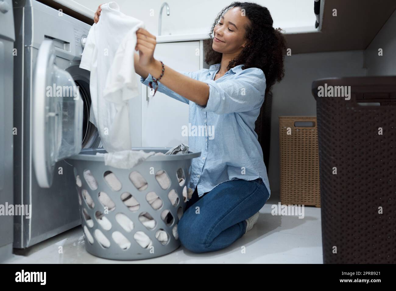 Cette lessive en poudre rend les vêtements étincelants. une jeune femme se  préparant à laver une charge de linge à la maison Photo Stock - Alamy