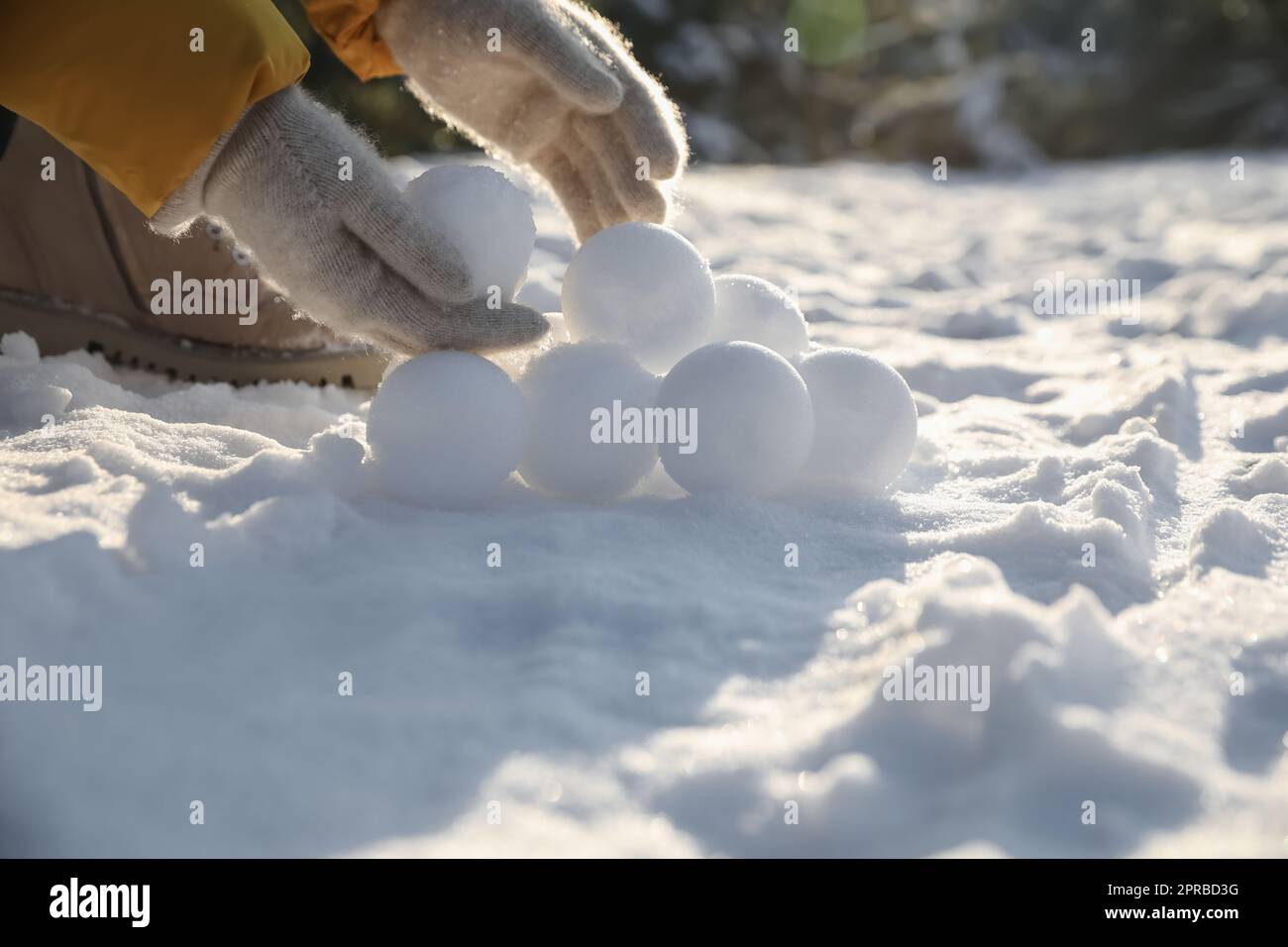 Femme roulant des boules de neige à l'extérieur le jour d'hiver, gros plan Banque D'Images