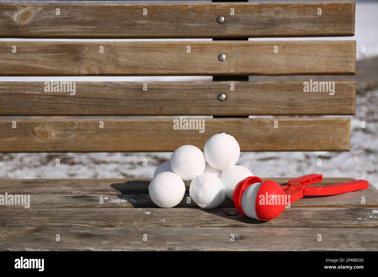 Boules de neige et outil en plastique sur le banc à l'extérieur Banque D'Images