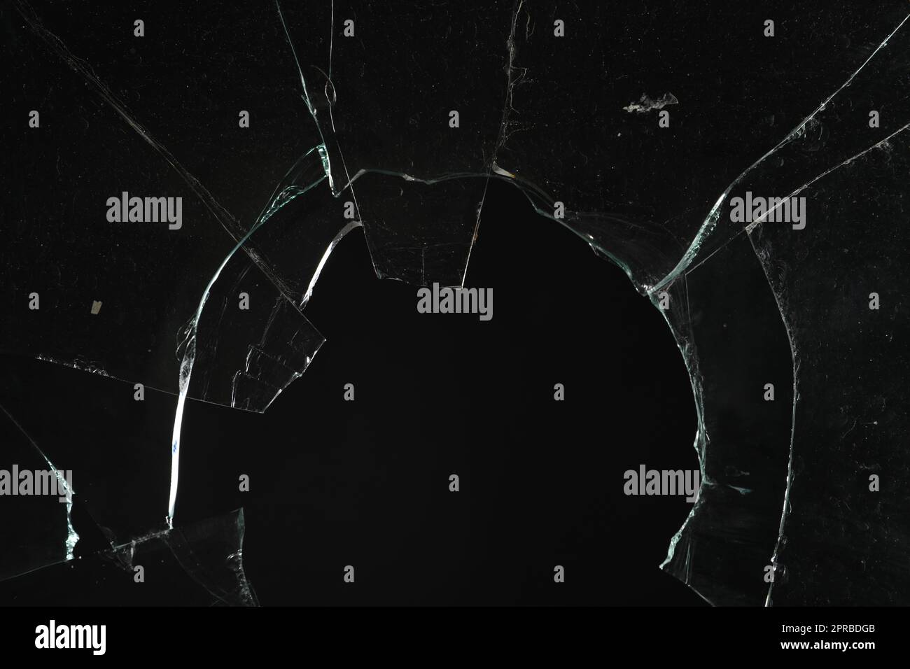 Vue en gros plan de verre brisé avec fissures sur fond noir Banque D'Images