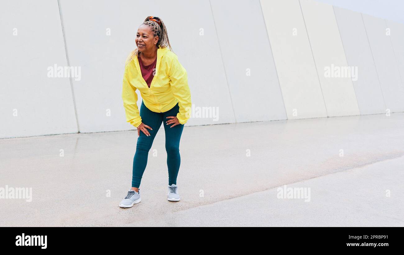 Sport femme africaine senior qui prend souffle avant de courir entraînement dans la ville - personnes âgées sain style de vie Banque D'Images