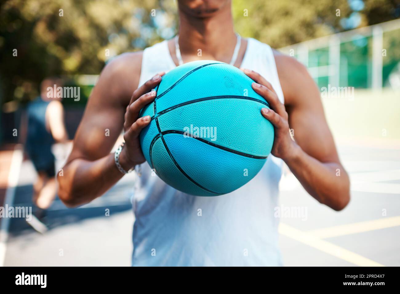 Tout simplement. Gros plan d'un sportif tenant un ballon de basket sur un terrain de sport. Banque D'Images