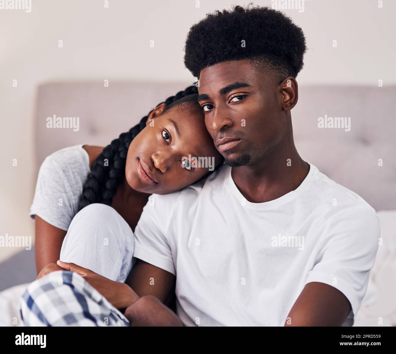 L'amour en vaut la peine. Un couple affectueux se détendant sur son lit portant un pyjama. Banque D'Images