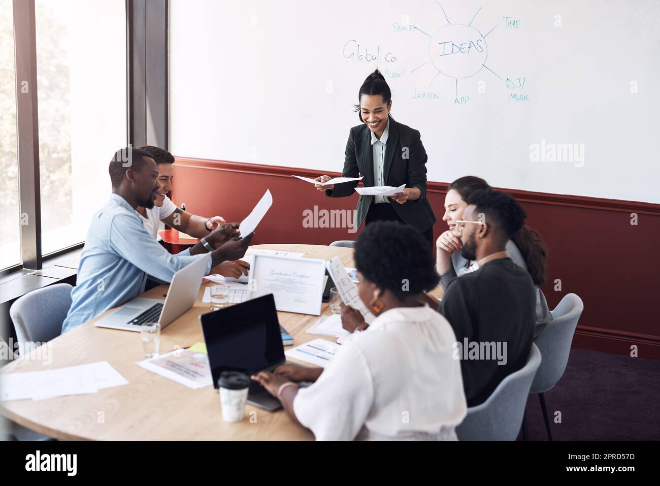 Leurs grandes idées afflueront sur le marché mondial. Une jeune femme d'affaires fera une présentation à ses collègues dans une salle de réunion. Banque D'Images