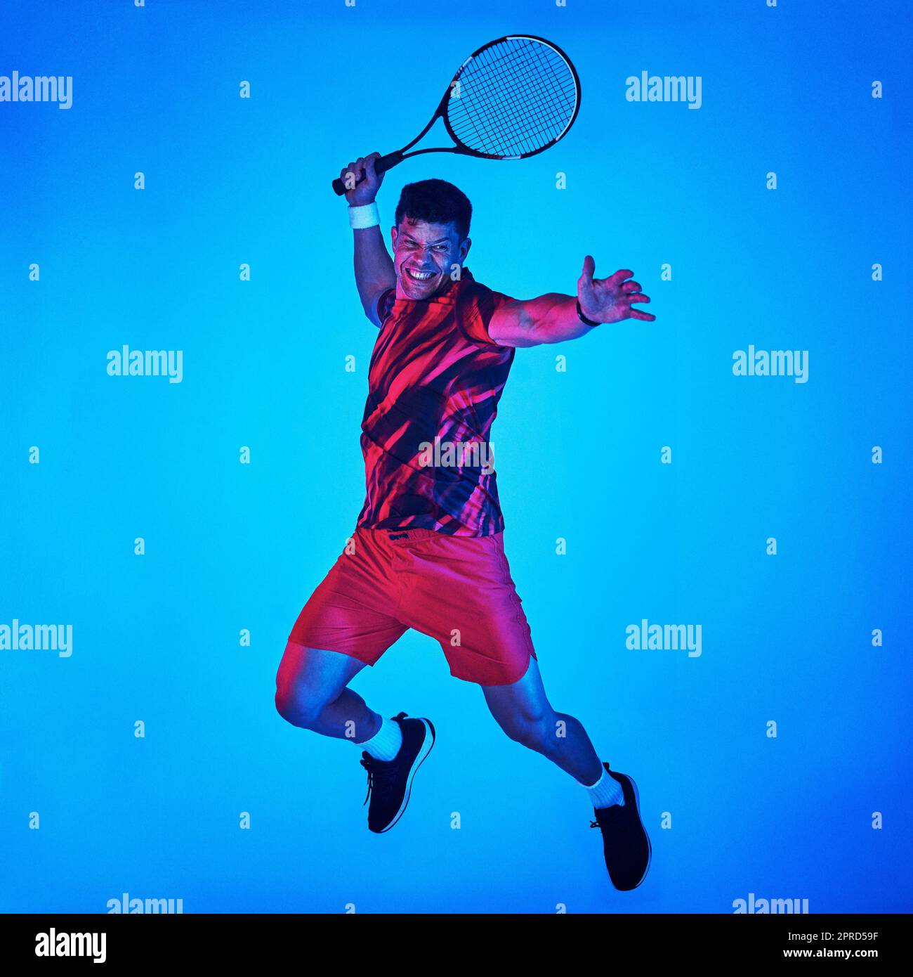 Il n'y a rien qu'un jeu de tennis ne peut pas réparer. Vue filtrée bleue d'un homme posant avec une raquette de tennis dans le studio. Banque D'Images