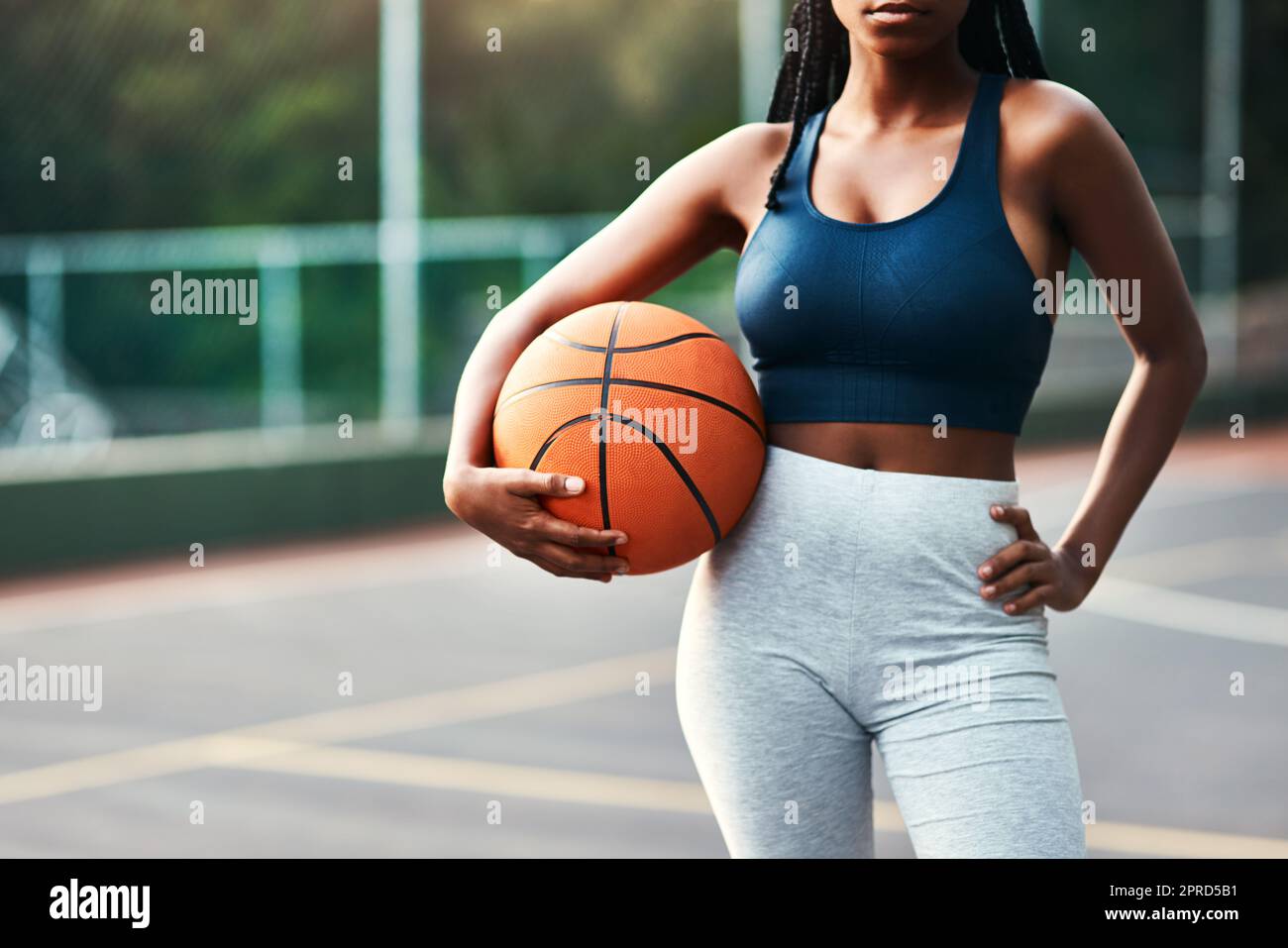 Je suis sur le terrain. Une sportswoman méconnaissable debout sur le terrain seul et tenant un basket-ball pendant la journée. Banque D'Images