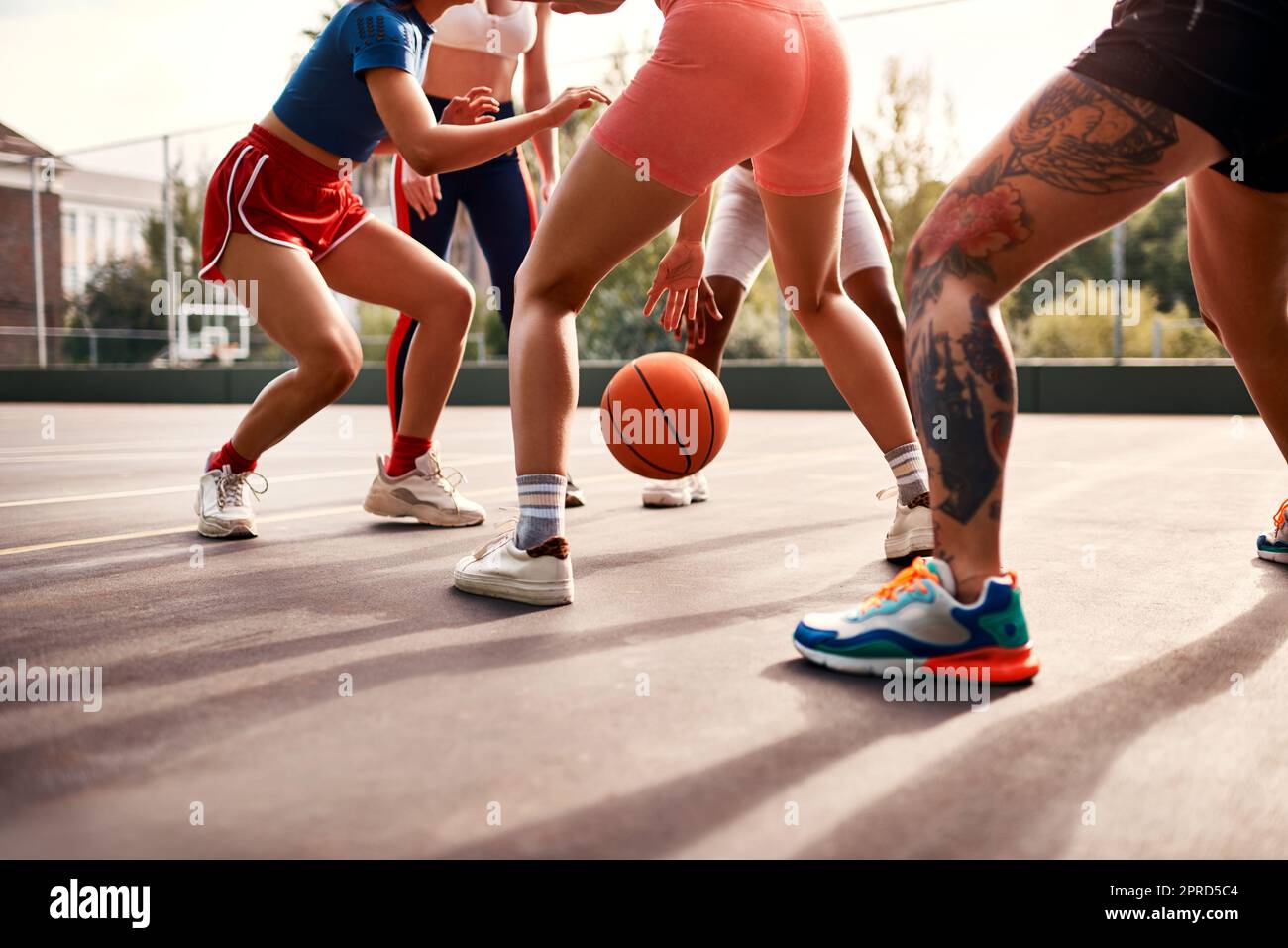 Où est l'action principale. Un groupe diversifié de sportswomen jouant un jeu compétitif de basket-ball ensemble pendant la journée. Banque D'Images