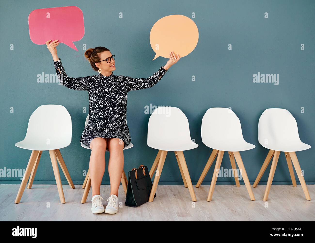 C'est ainsi. Photo en studio d'une jeune femme d'affaires attirante tenant des bulles de la parole tout en restant dans la ligne sur un fond gris. Banque D'Images