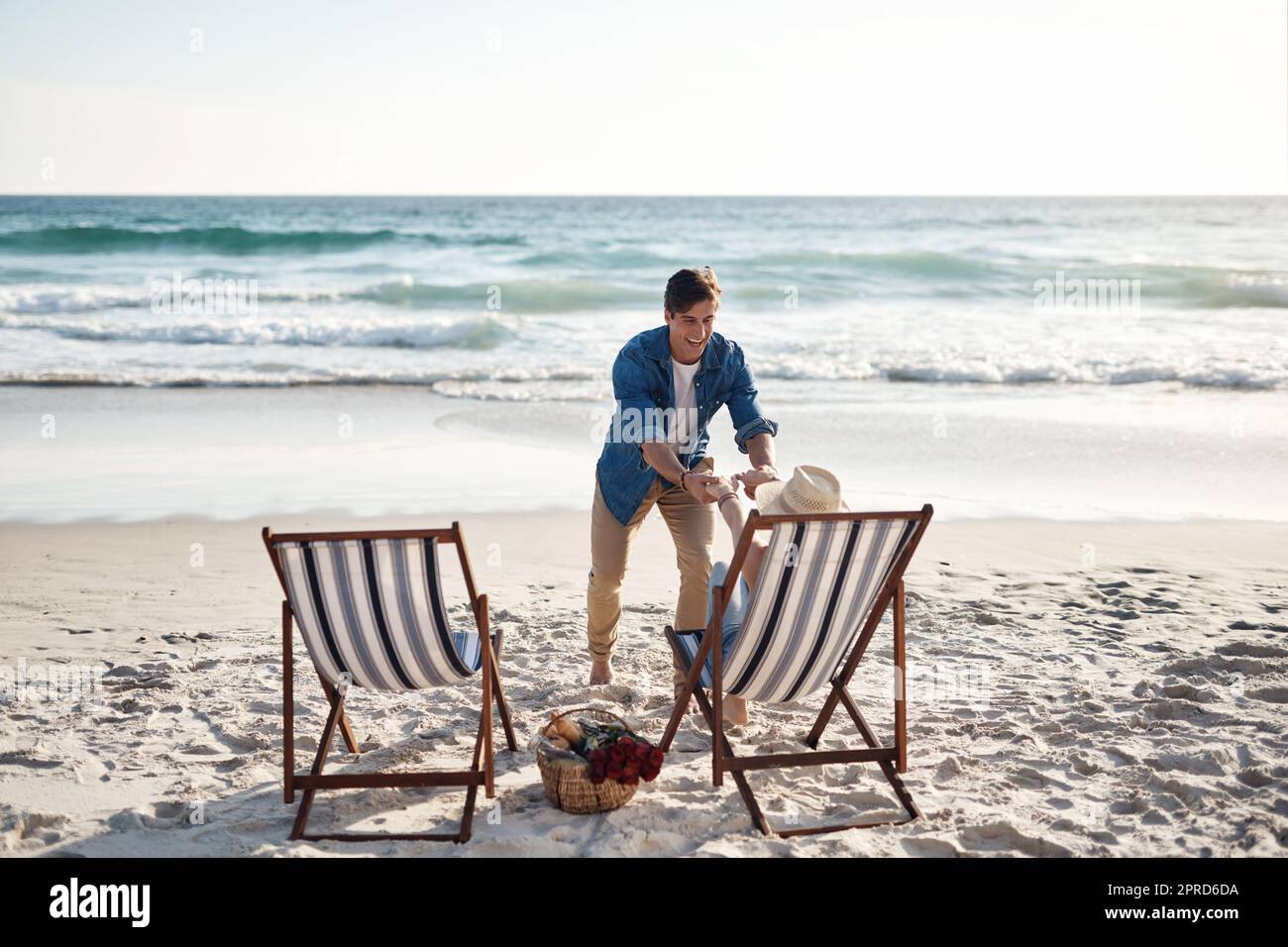Allons nous mouiller les pieds. Vue arrière d'un couple d'âge moyen assis dans leurs chaises de plage sur la plage. Banque D'Images