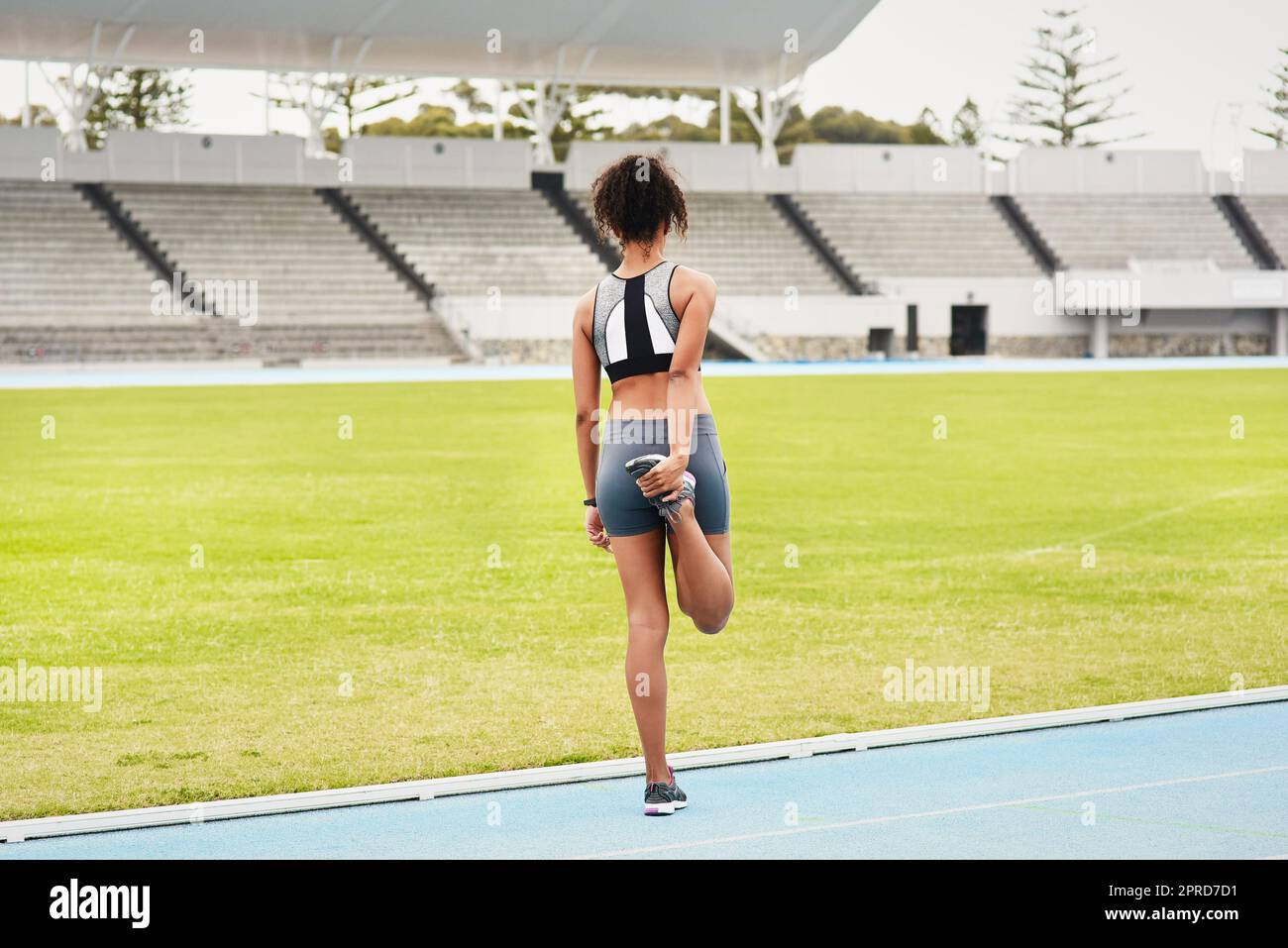 Rien ne vaut un bon étirement. Prise de vue en arrière d'une jeune athlète féminine qui s'échauffe sur la piste. Banque D'Images