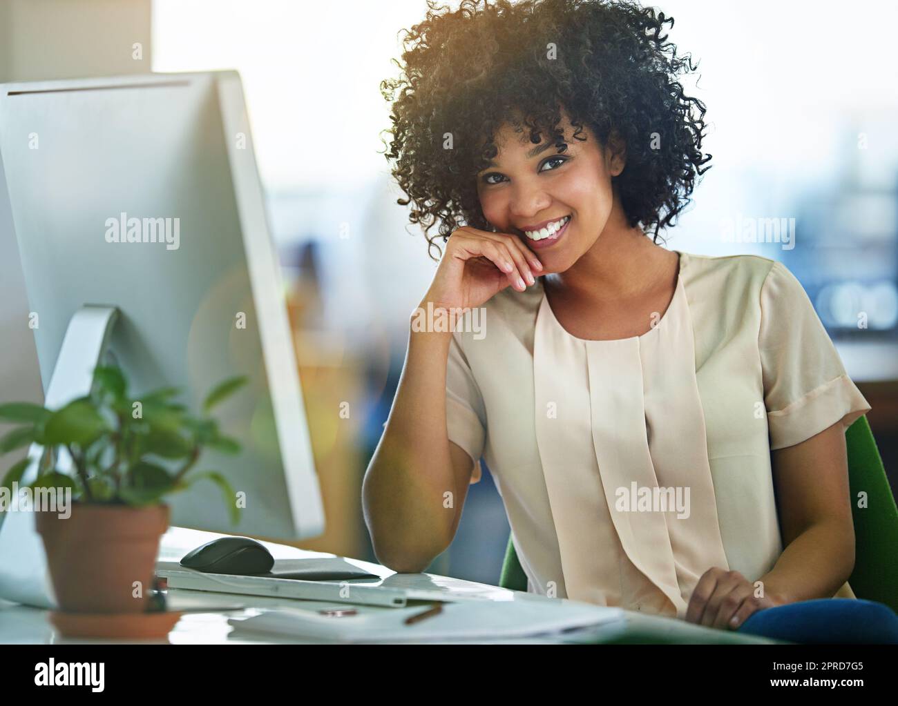 Femme d'affaires prospère, heureuse et confiante assise à l'ordinateur au bureau avec un état d'esprit positif. Belle femme entrepreneure en bonne santé ou leader innovant et digne de confiance souriant pendant le travail. Banque D'Images