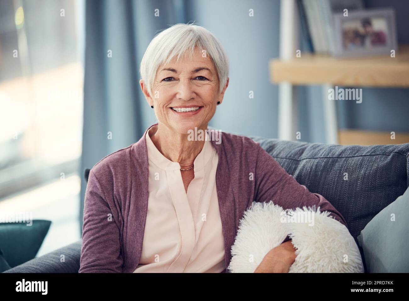 Soixante-dix est la nouvelle cinquante. Portrait court d'une femme âgée heureuse se reposant confortablement sur son canapé à la maison. Banque D'Images