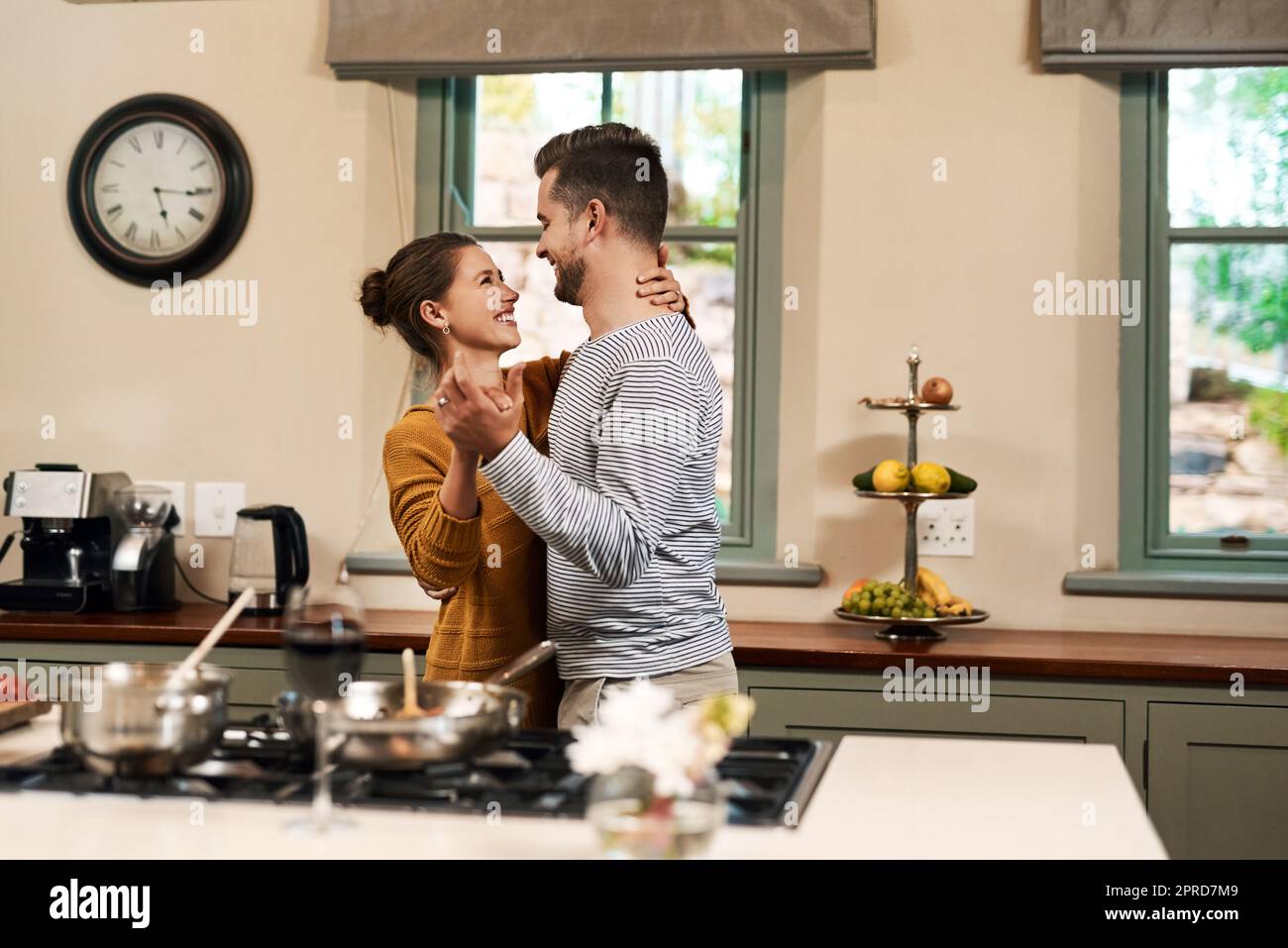 Si vous dansez, c'est la nourriture de l'amour... un jeune couple affectueux dansant ensemble dans leur cuisine à la maison. Banque D'Images