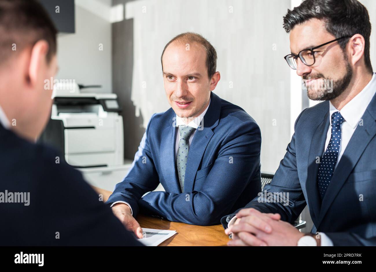 Équipe de personnes en confiance qui ont réussi à discuter des conditions du contrat lors d'une réunion d'affaires dans un bureau d'entreprise moderne. Banque D'Images