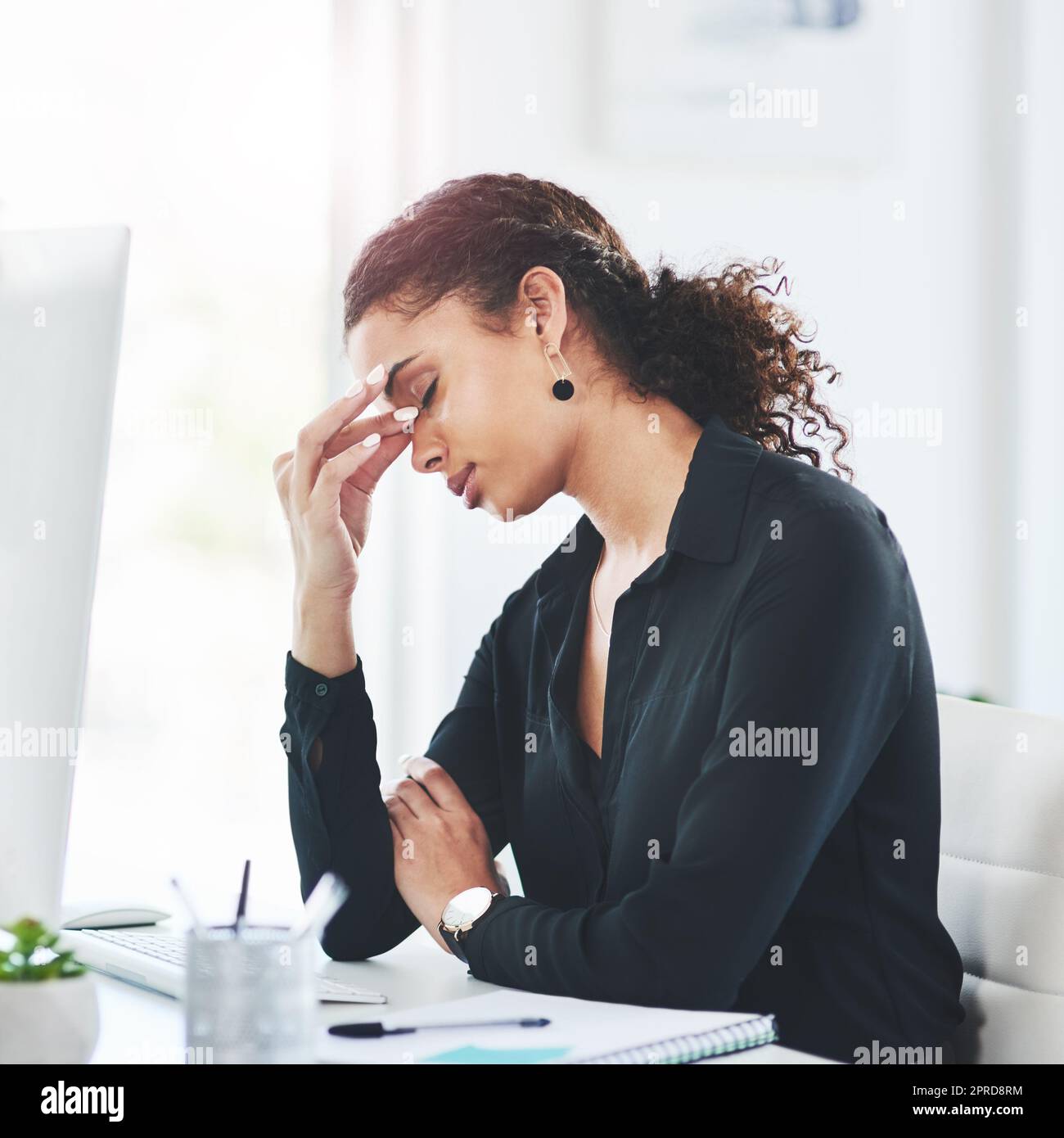 Je ne peux pas saisir la journée avec tout ce stress. Une jeune femme d'affaires qui regarde stressée pendant qu'elle travaille dans un bureau. Banque D'Images