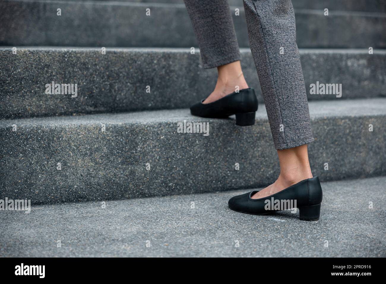 Gros plan les jambes d'une femme d'affaires se précipitent sur l'escalier Banque D'Images