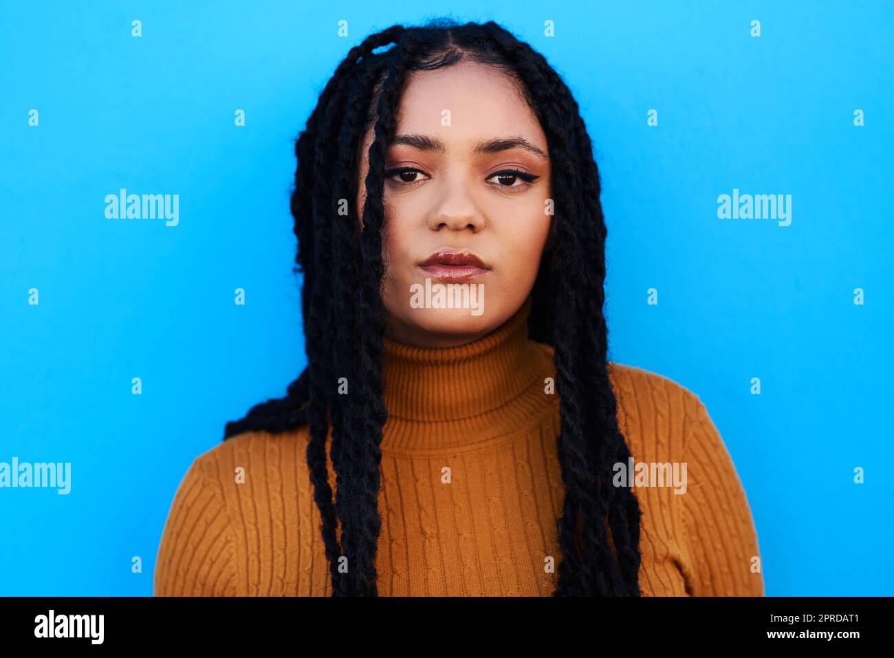 Soyez deux choses qui et ce que vous voulez être. Une belle jeune femme posant contre un mur bleu. Banque D'Images