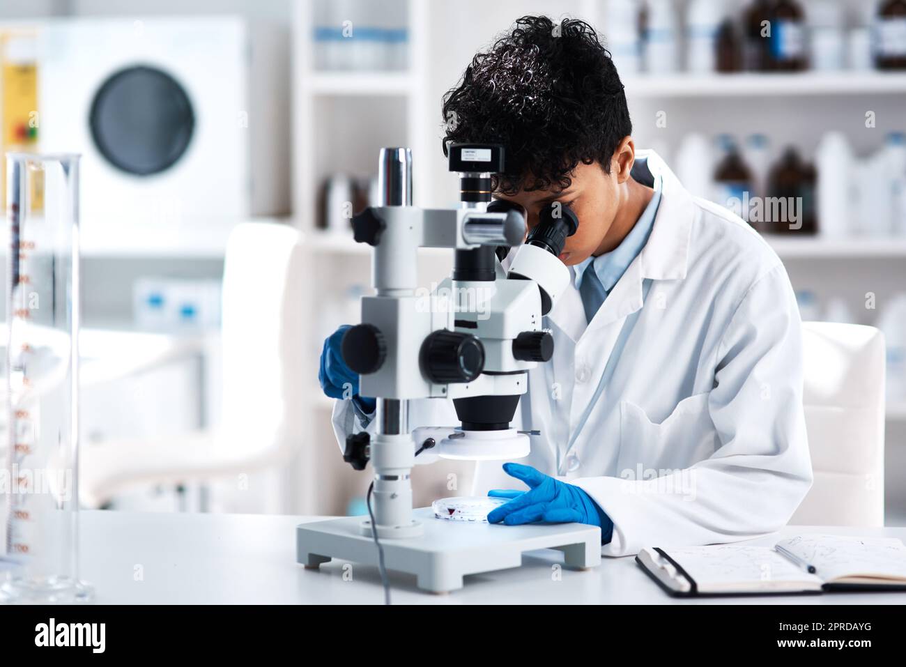 La science élargit les perspectives. Un jeune scientifique utilisant un microscope dans un laboratoire. Banque D'Images
