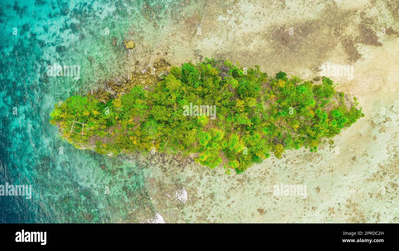 Les îles sont la destination de vacances idéale. Photo en grand angle d'un petit îlot au milieu des merveilleuses îles Raja Ampat en Indonésie. Banque D'Images