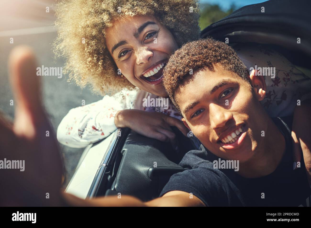 Nous adorons les longs trajets en voiture. Un jeune couple heureux sur la route. Banque D'Images