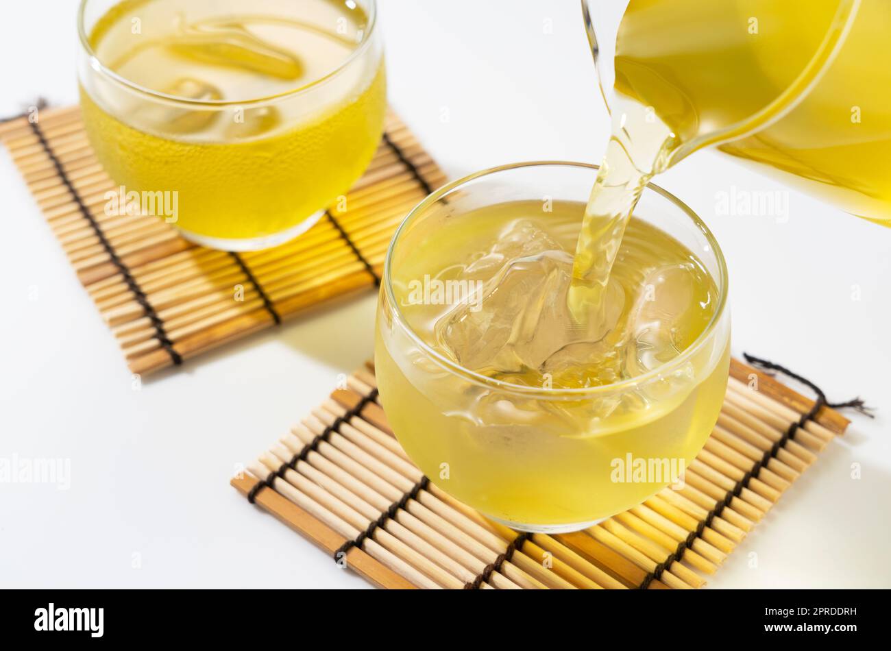 Verser le thé vert dans une théière en verre remplie de glace. Banque D'Images