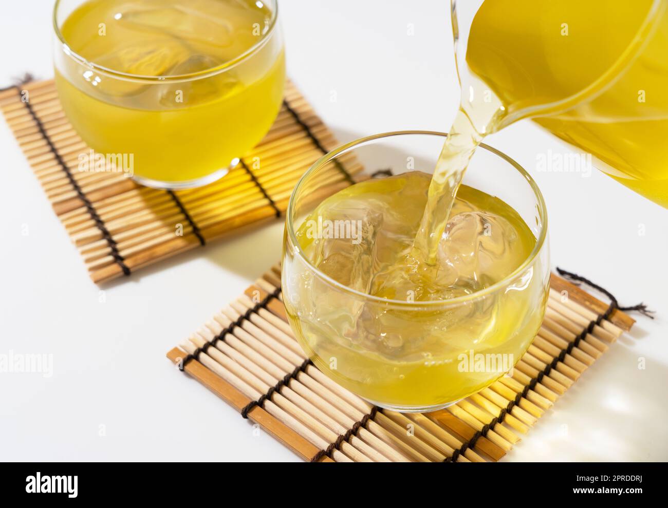 Verser le thé vert dans une théière en verre remplie de glace. Banque D'Images