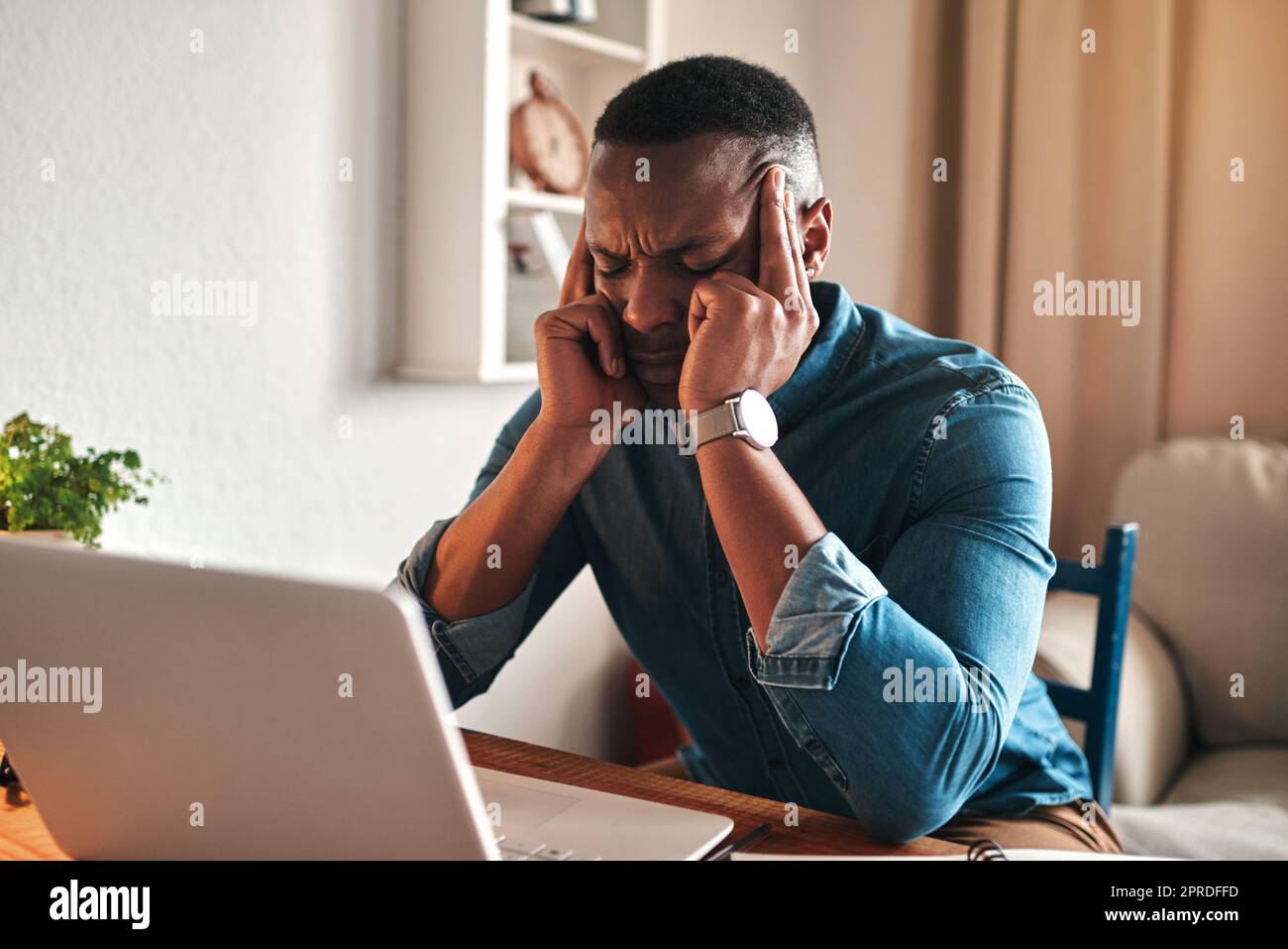 Stress, douleur et maux de tête tout en travaillant à distance sur un ordinateur portable à partir du bureau à domicile, l'homme freelance s'est énervé et a subi des pressions. Homme frustré souffrant d'une migraine, de la pression de la charge de travail ou d'un délai Banque D'Images