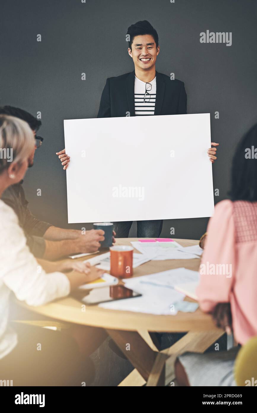 Équipe créative et décontractée faisant une présentation amusante avec une carte vierge, un panneau d'affichage ou une affiche dans un bureau moderne. Bonne équipe diversifiée travaillant ensemble, partageant une idée ou un plan d'affaires tout en remue-méninges Banque D'Images