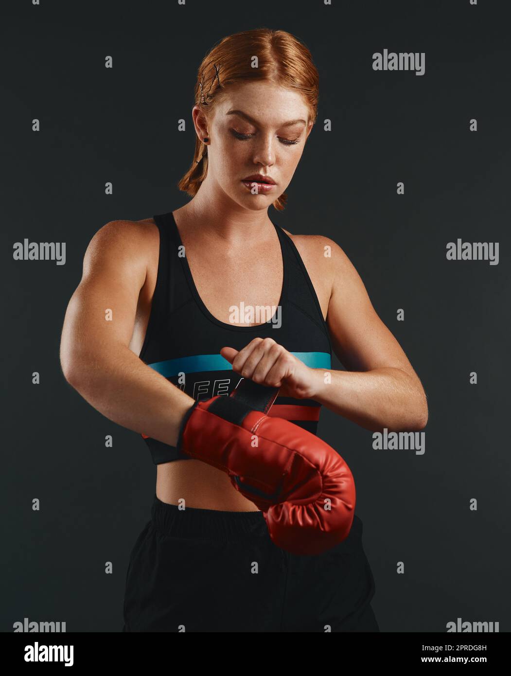 Assez de parler, battons. Photo en studio d'une jeune femme sportive portant des gants de boxe sur fond noir. Banque D'Images