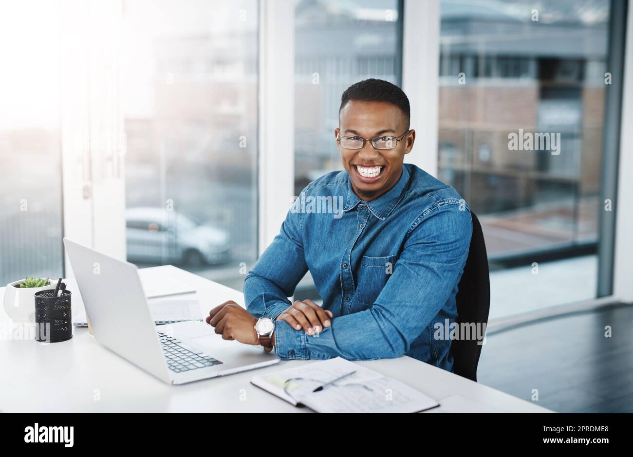 Le seul homme chanceux est celui qui travaille dur. Portrait d'un jeune homme d'affaires travaillant à son bureau dans un bureau moderne. Banque D'Images