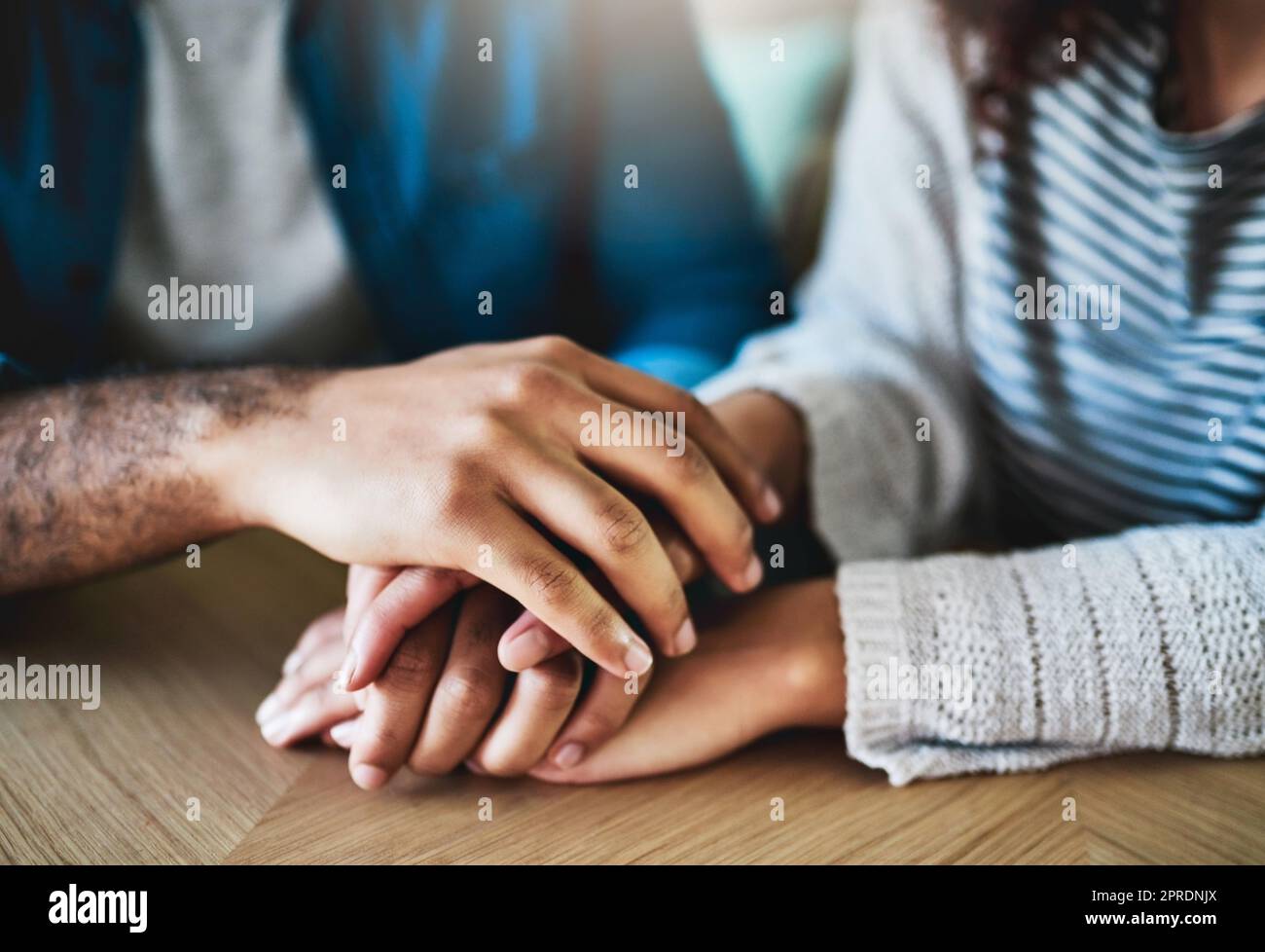 Je vous remercie un homme et une femme qui tiennent avec compassion les mains à une table. Banque D'Images