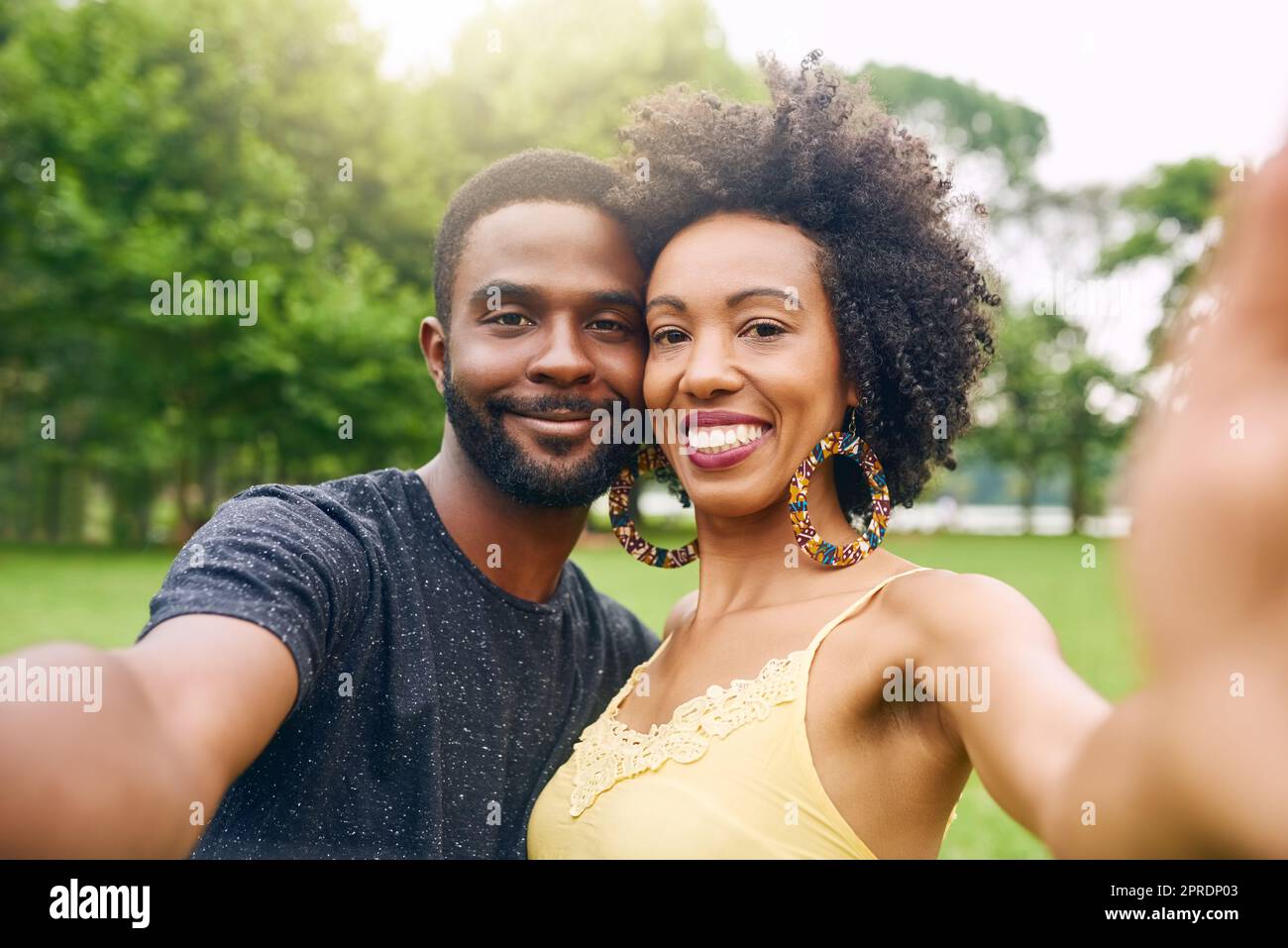 C'est un couple de livres d'images. Portrait court d'un jeune couple affectueux prenant des selfies tout en passant du temps dans le parc. Banque D'Images