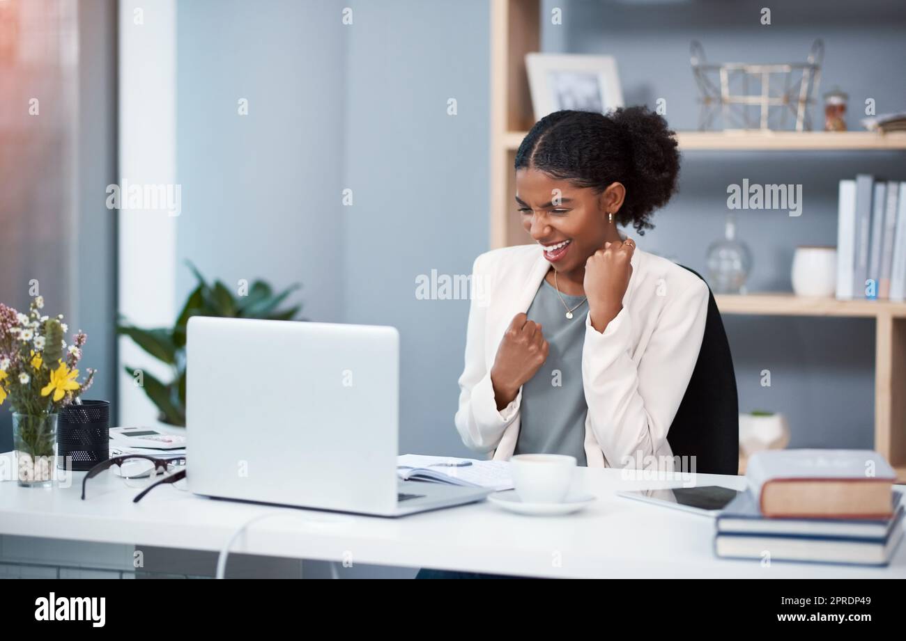 Des créations enthousiastes avec un ordinateur portable qui célèbre le succès, applaudit les bonnes nouvelles ou fait après avoir atteint l'objectif, l'échéance du marché ou terminé une tâche de bureau. Agent de marketing avec le geste de poing montrant l'expression de la barre de hurray Banque D'Images