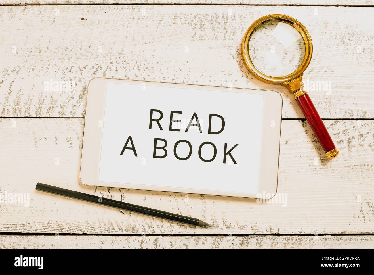 Légende de texte Présentation Lire Un livre. Photo conceptuelle Profitez de la littérature activité traditionnelle Apprenez de nouvelles choses écran de tablette avec de nouvelles idées avec loupe et crayon autour. Banque D'Images