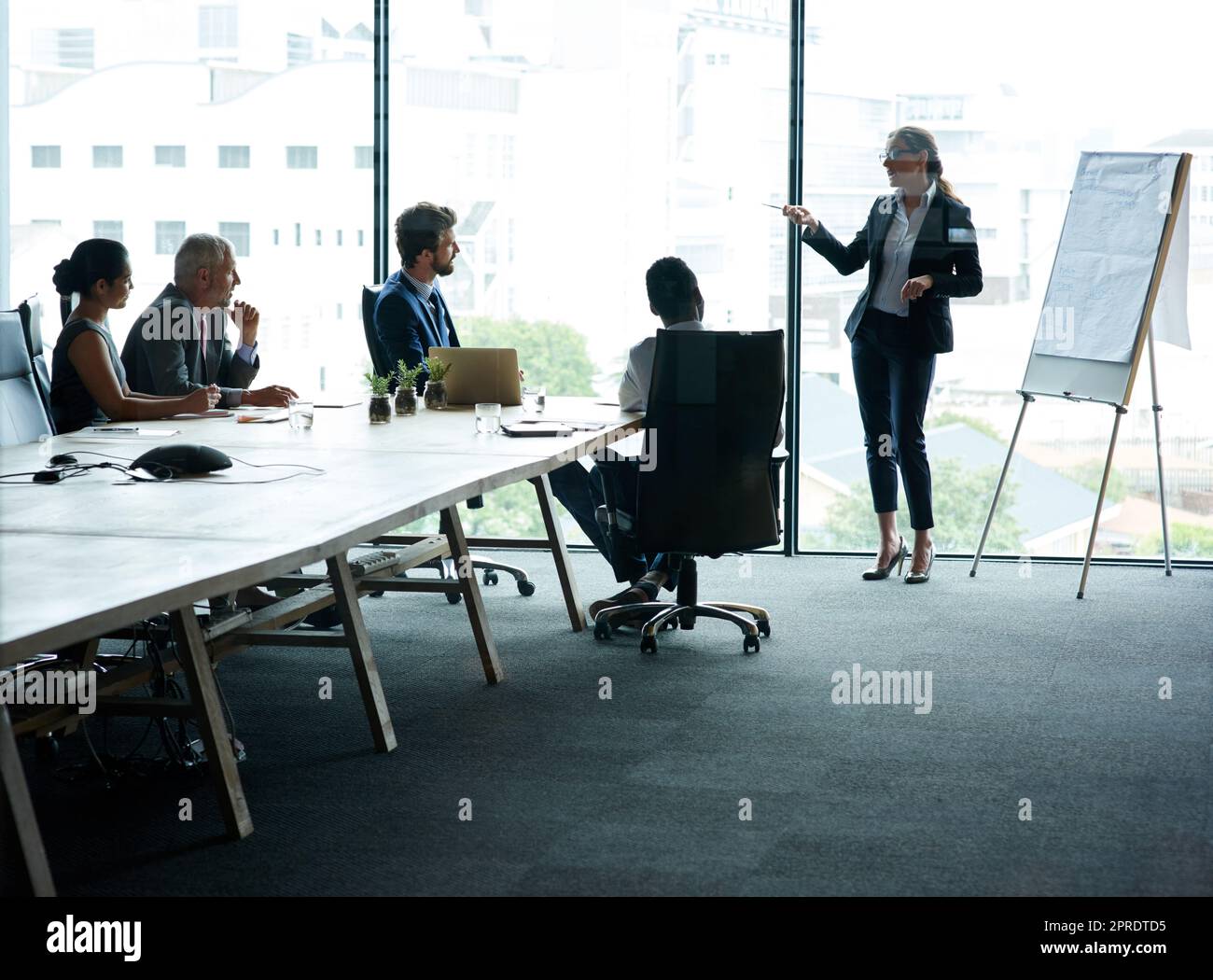 Une femme responsable forme une équipe d'hommes d'affaires à une réunion de bureau. Chef créatif professionnel parlant dans un atelier de présentation, un séminaire d'éducation et une conférence avec un groupe de collègues Banque D'Images