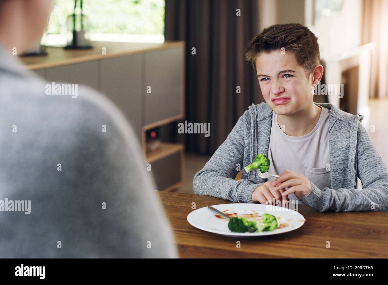 Mais j'ai eu des légumes l'année dernière. Une mère qui dit à son fils de manger son brocoli qu'il n'aime pas. Banque D'Images