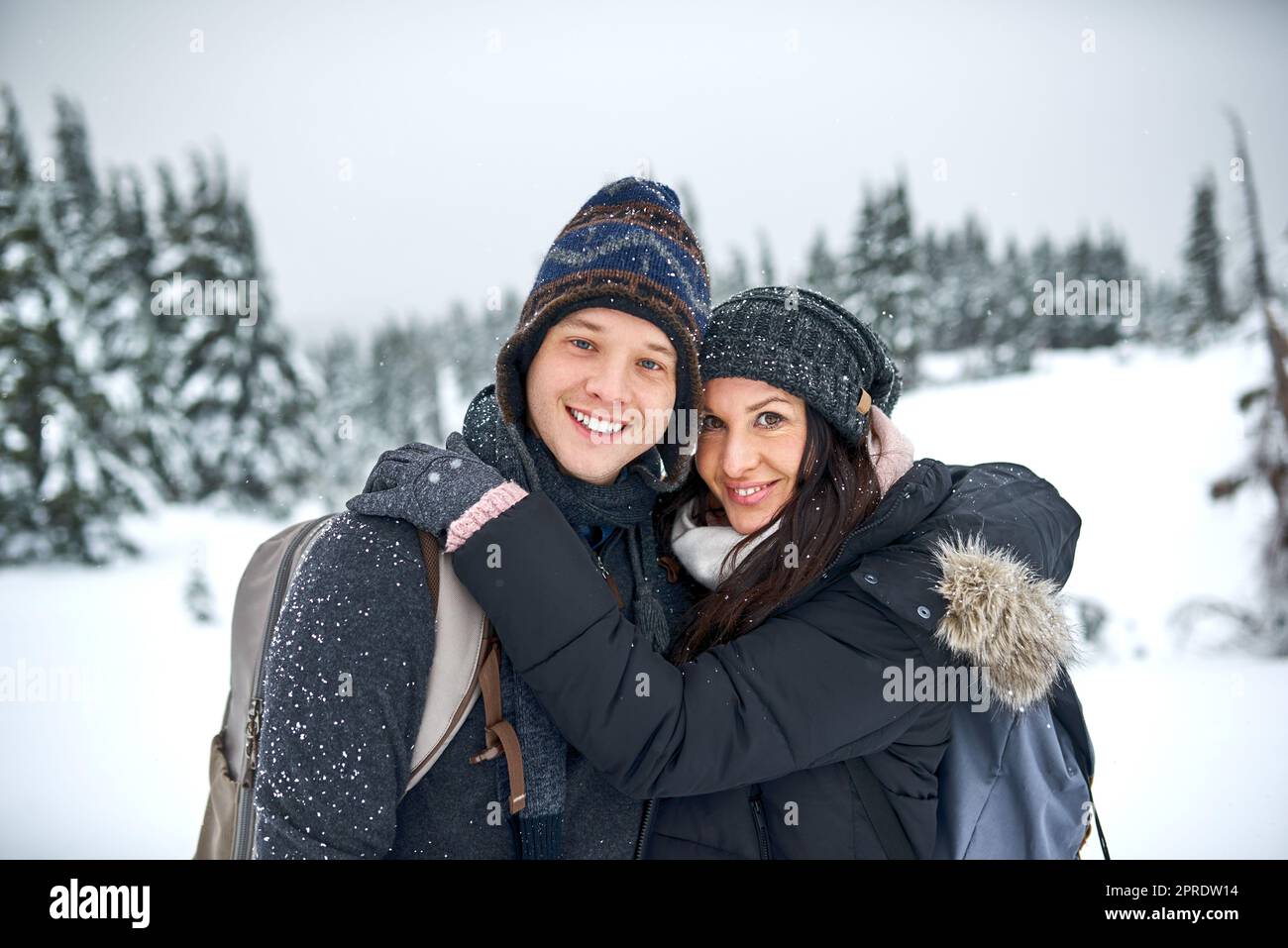 L'amour de l'hiver est bien mieux que l'amour de l'été. Un jeune couple heureux s'appréciant tout en étant dehors dans la neige. Banque D'Images