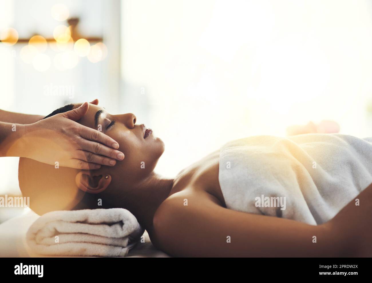 Vivez dans une ambiance détendue. Une jeune femme attirante se fait masser au spa. Banque D'Images