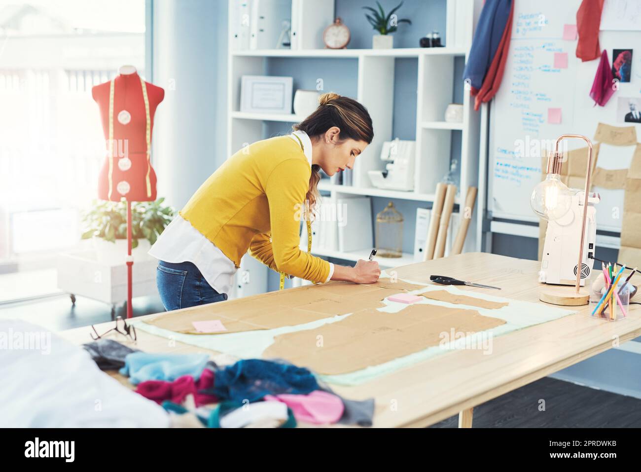 C'est beau quand une passion et une carrière se réunissent. Un jeune designer de mode attrayant dans son atelier. Banque D'Images