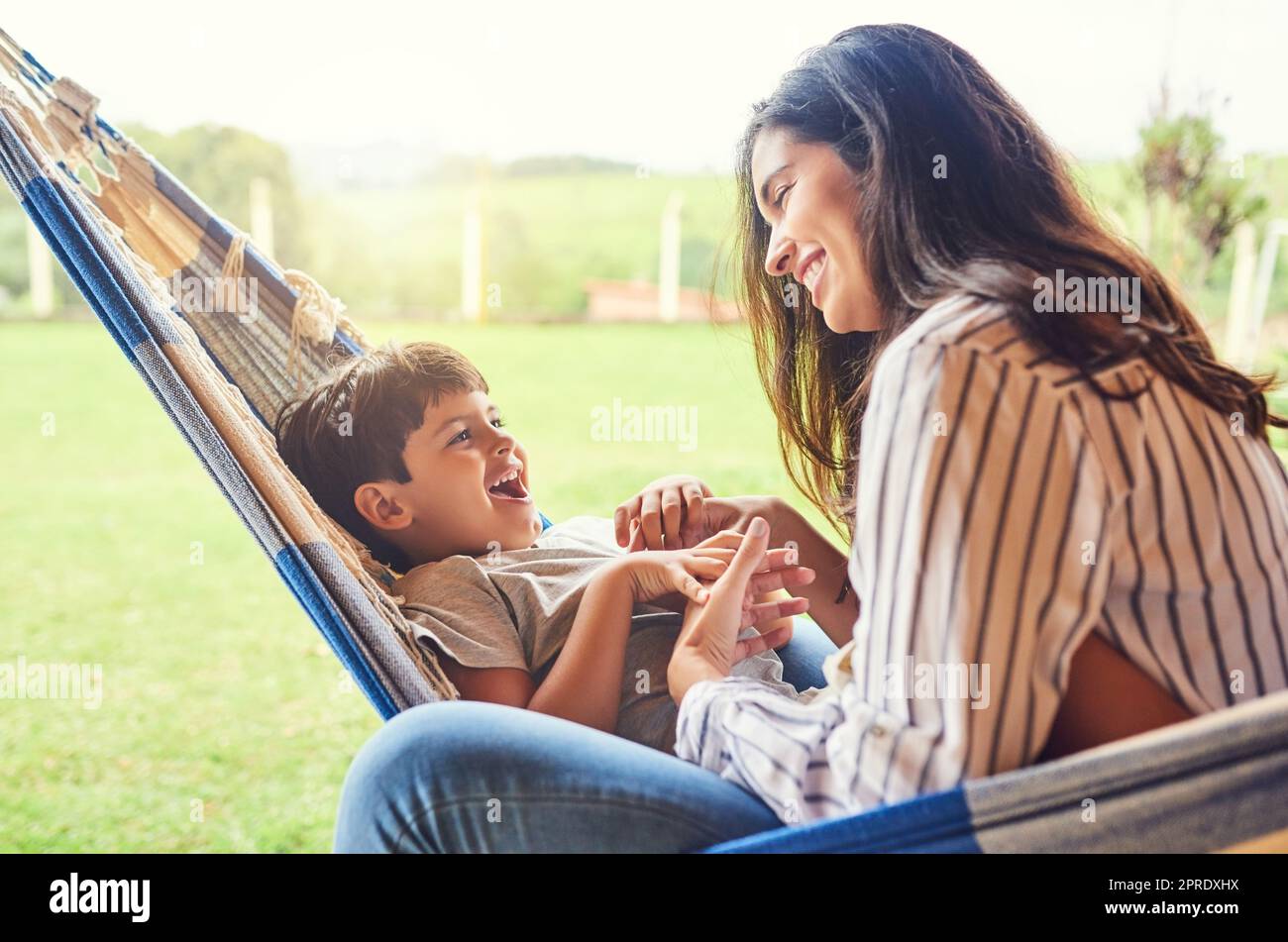 Passer un peu de temps seul avec son fils. Une jeune femme attrayante et son fils se liant à l'extérieur sur le hamac. Banque D'Images