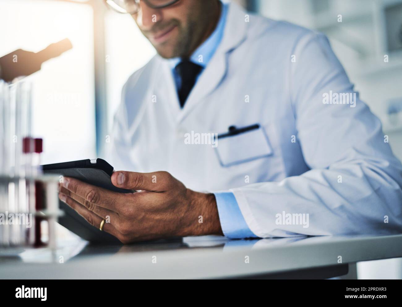 Prouver une autre théorie encore correcte. Un scientifique utilisant une tablette numérique tout en travaillant dans un laboratoire. Banque D'Images